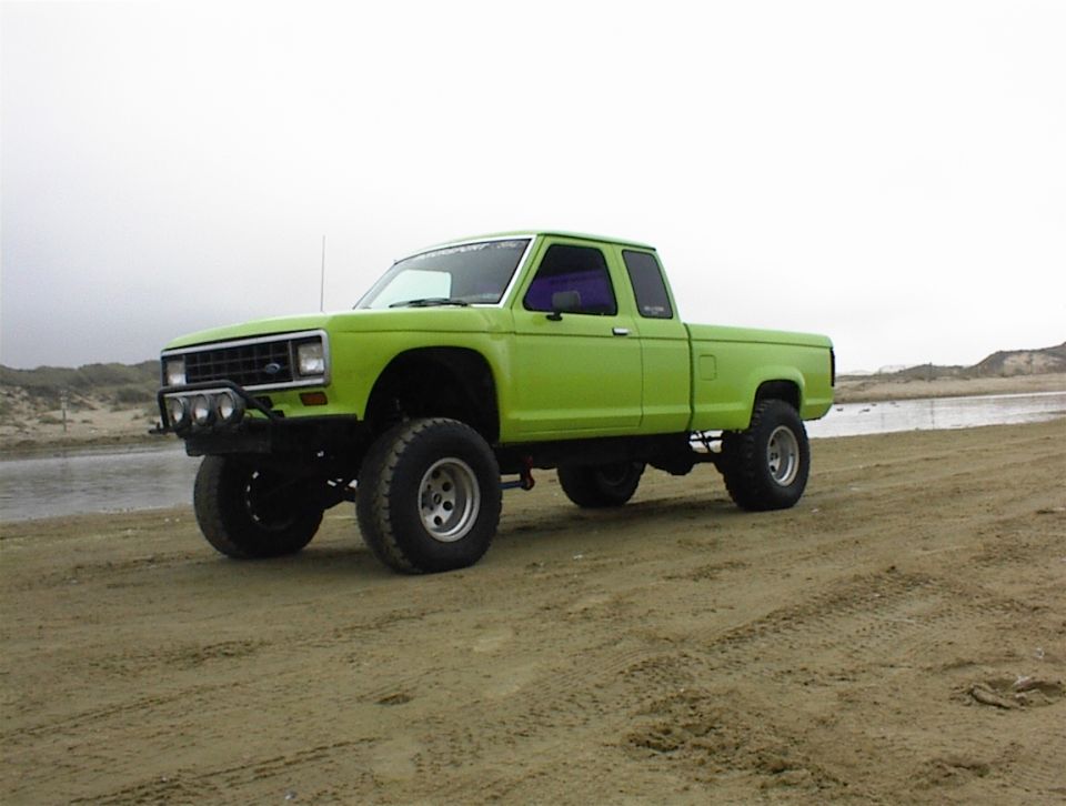Lime green lifted pickup truck parked on a sandy beach