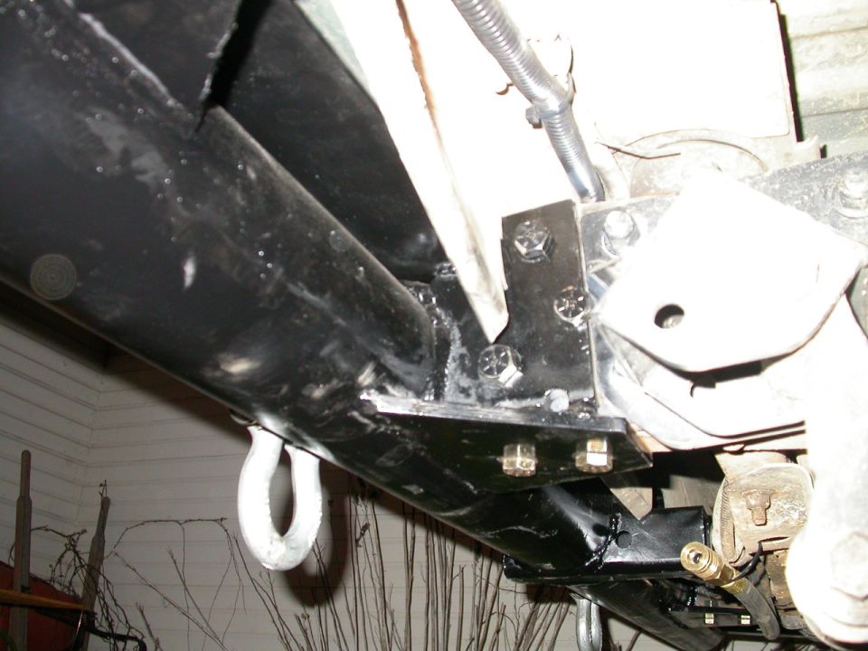 Bolted to frame via three stock mounting holes plus two more in bottom of frame rails, with grade 8 bolts.