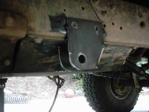 1978 Ford Bronco - A custom suspension bracket is attached to the frame of a vehicle, with a tire visible in the background.