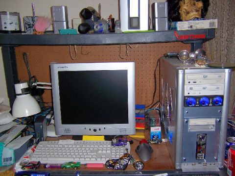 2002 Ford Crown Victoria - A cluttered desk features a computer setup with various accessories and miniature vehicles.