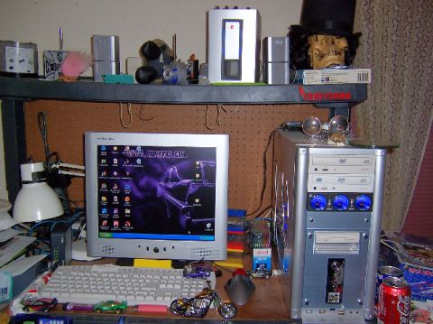 2002 Ford Crown Victoria - A cluttered desk features a computer monitor, keyboard, and tower, with a decorative skull in a top hat on a shelf above.