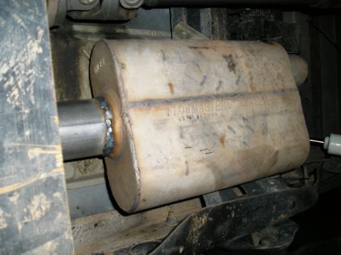1993 Ford Bronco - Close-up view of a Flowmaster muffler, showing its welded connection to the exhaust pipe and visible patent information.