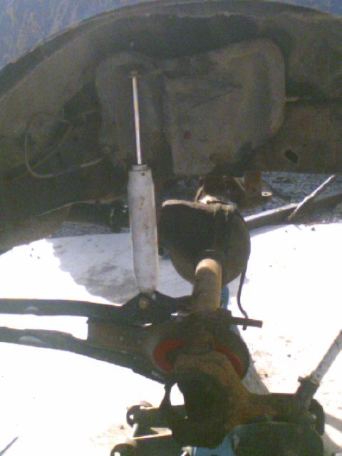 1989 Ford Bronco - Undercarriage view of suspension parts, including a shock absorber and axle components.
