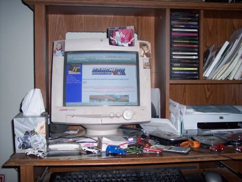 1972 Ford Ranchero - A computer monitor displays a website about Rancheros, surrounded by various items on a cluttered desk.