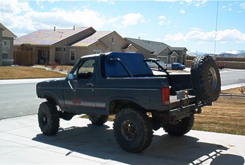 1986 Ford Bronco - This lifted Ford Bronco, likely from the early 1980s, is parked in a suburban driveway.