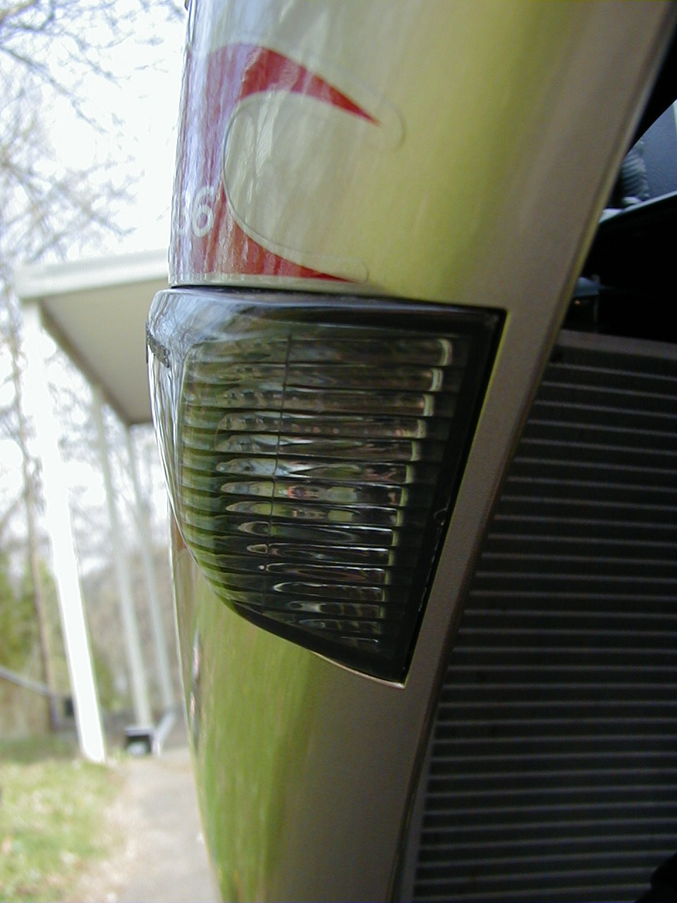 Close-up of a 2006 Kawasaki Ninja front turn signal with red and white graphic on fairing above
