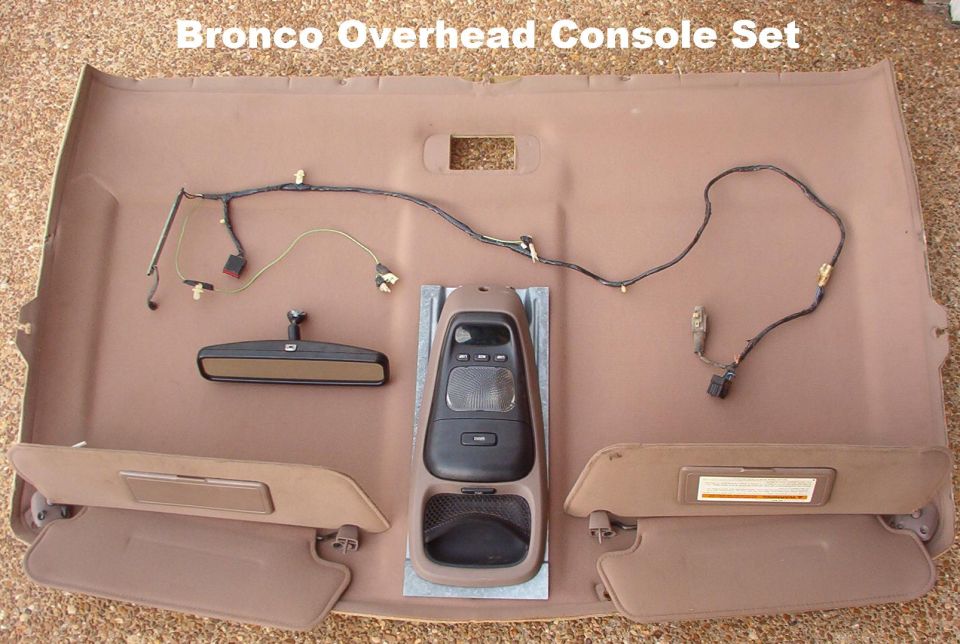 Tan Bronco overhead console set with headliner, mirror, sun visors and wiring harness on driveway