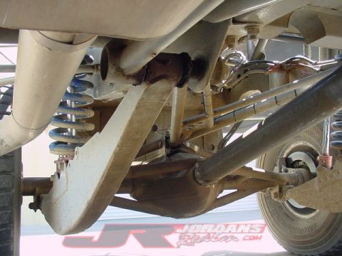 1984 Ford Bronco - Close-up of the complex suspension components and drivetrain of an off-road vehicle.