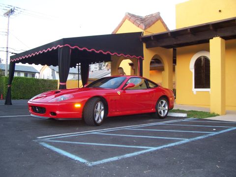 1994 Ford Probe - Red Ferrari parked in front of a yellow building with a black awning.