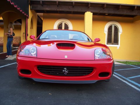 1994 Ford Probe - A red Ferrari is parked in front of a yellow building with arched windows.