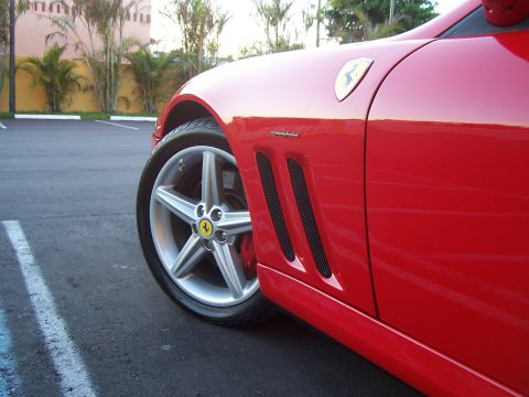1994 Ford Probe - A close-up of a red Ferrari's side profile, highlighting its iconic wheel design and aggressive fender vents.