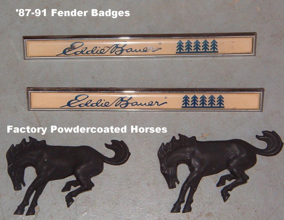Two Eddie Bauer fender badges and two cast horse emblems labeled 87-91 fender badges and factory powdercoated horses