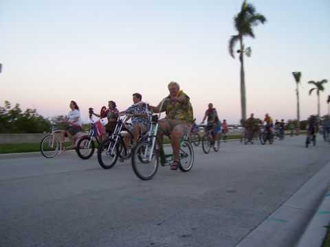 1994 Ford Probe - A group of people enjoy a ride on cruiser bicycles along a coastal road at sunset.