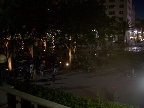 1994 Ford Probe - A nighttime scene shows a gathering of people and numerous bicycles in a park setting, illuminated by decorative lights.