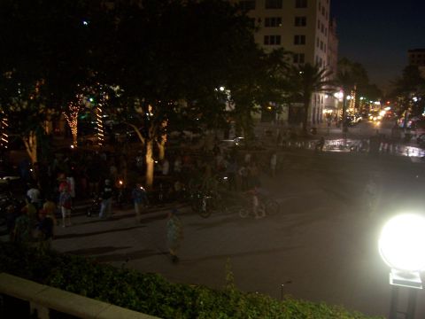 1994 Ford Probe - A busy street scene at night with illuminated trees and a crowd of people.