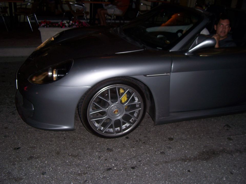 Grey Porsche convertible at night on multi-spoke wheels with yellow brake calipers
