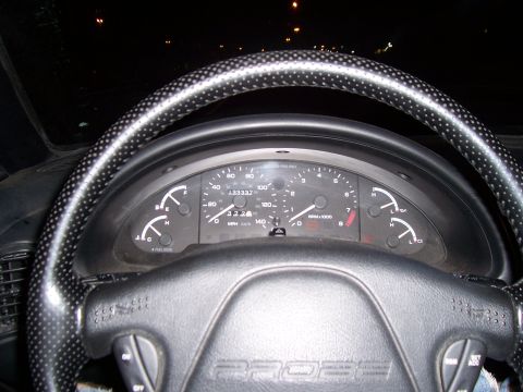 1994 Ford Probe - The interior of a 1994 Ford Probe shows the dashboard gauges and steering wheel, with the odometer displaying 133,337 miles.