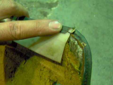 1979 Ford Bronco - Damaged upholstery shows exposed foam and torn fabric, with a finger indicating the damage.