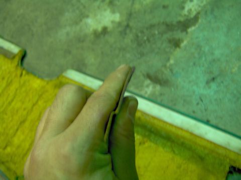 1979 Ford Bronco - A hand holds a piece of trim, possibly from a vehicle interior.