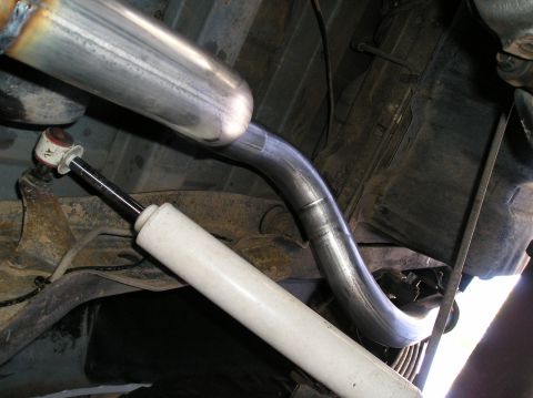 1993 Ford Bronco - Undercarriage view of an exhaust pipe and shock absorber, likely from a truck or SUV.