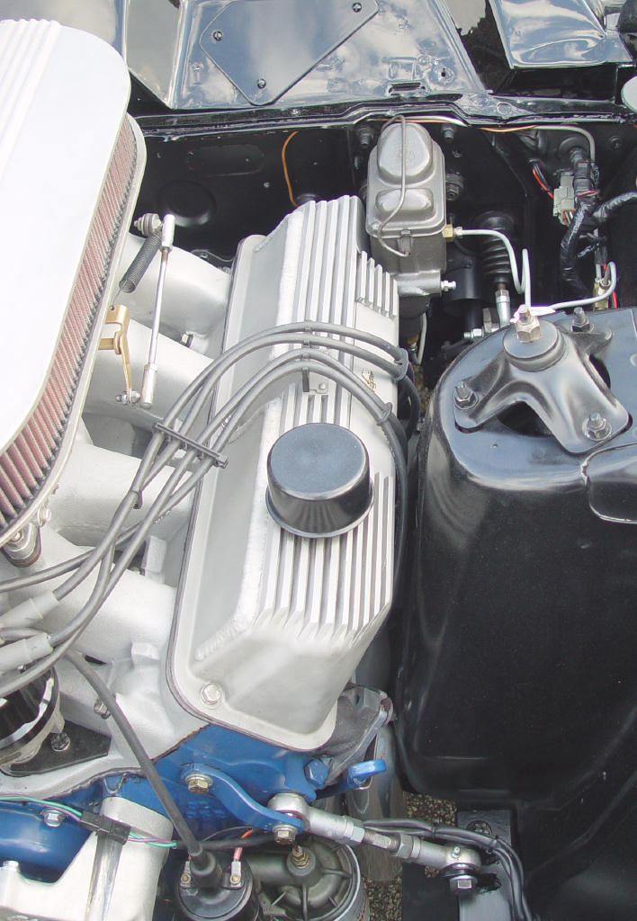 V8 engine bay detail with finned aluminum valve covers and oval air cleaner