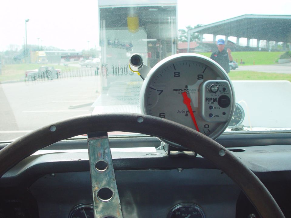 Car interior with wood steering wheel and Auto Meter tachometer on dash