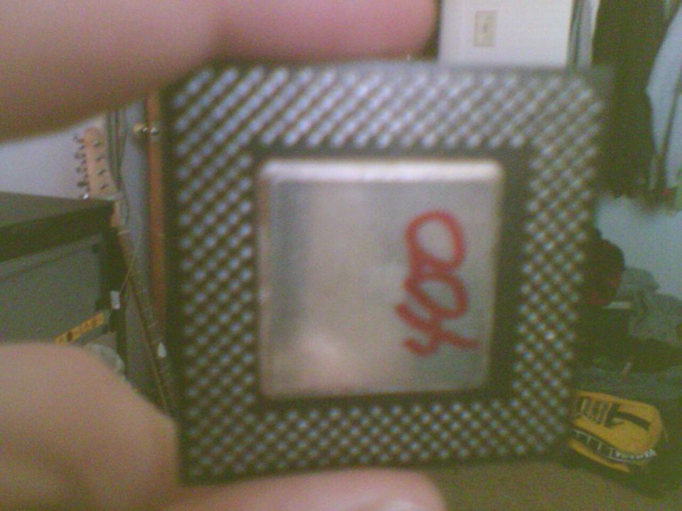 Computer processor with red markings '400' held by a finger
