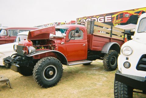 1989 Ford F-350 - A classic red Dodge Power Wagon is displayed with its hood up, its engine and large off-road tires.