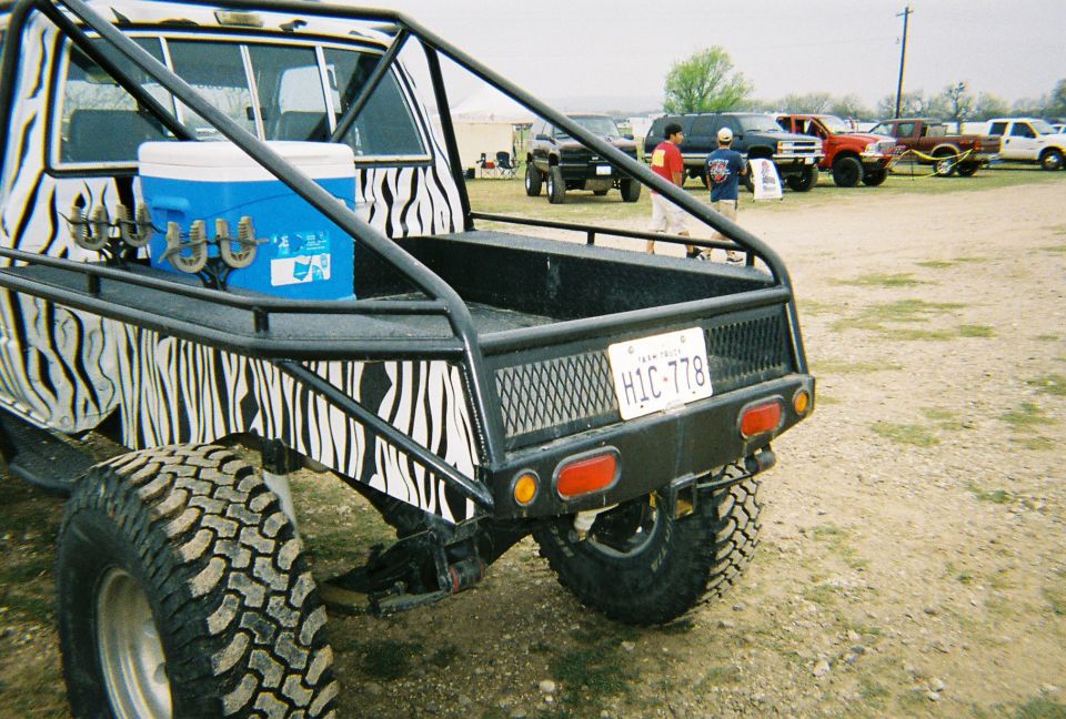 1989 Ford F-350 pickup truck with zebra print bed and roll cage, rear view. License plate HIC-778