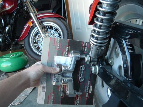 2002 Harley-Davidson Sportster Custom - A Kuryakyn USA part is held in front of a motorcycle's rear suspension.