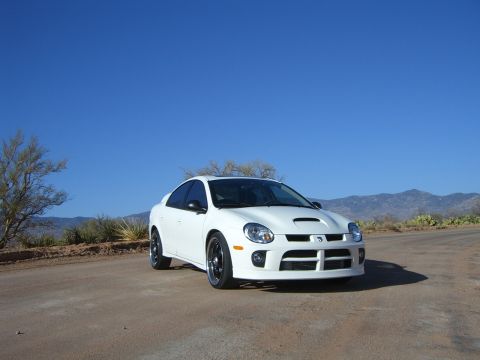 1996 Ford Probe - A white Dodge Neon SRT-4 is parked on a dirt road with a desert landscape in the background.