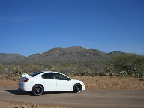 1996 Ford Probe - A white sedan with a spoiler is parked on a dirt road in a desert landscape.