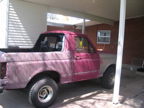 1991 Ford Bronco - This 1991 Ford Bronco is shown in a three-quarter front view, with one side painted red and the other in primer, indicating it is undergoin…