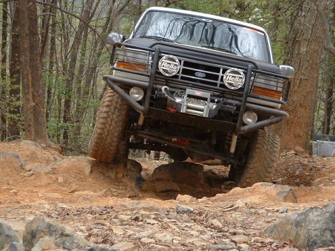 1987 Ford F-150 - This modified Ford truck tackles a challenging rocky trail, its off-road capabilities.