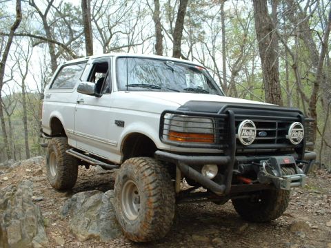 1987 Ford F-150 - This white Ford Bronco is equipped for off-road adventures with large tires and a front winch.