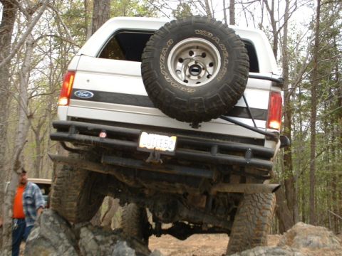 1987 Ford F-150 - This 1987 Ford Bronco is navigating a rocky trail, showing its rear end and spare tire.