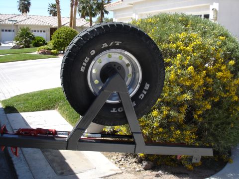 1996 Ford Bronco - Spare tire carrier with a Big O A/T tire mounted on a metal frame, with a red jack visible.