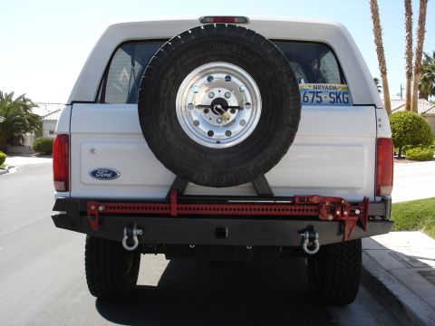 1996 Ford Bronco - This 1996 Ford Bronco features a spare tire and a red hi-lift jack mounted on its aftermarket rear bumper.