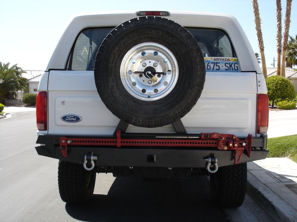 Rear of a white Ford SUV with spare tire on a custom rear bumper and Nevada plate 675-SKG