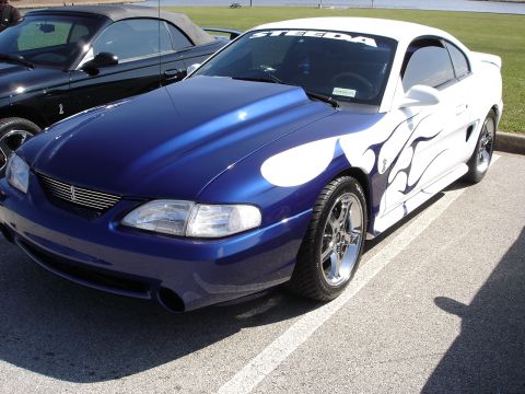 1998 Ford Taurus - Customized Ford Mustang with a two-tone blue and white paint scheme flame graphics and a prominent "STEEDA" banner.