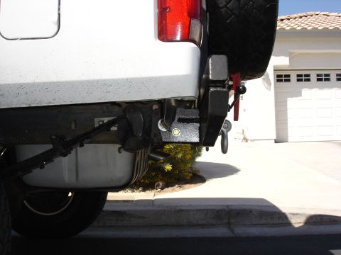 1996 Ford Bronco - Close-up of a vehicle's rear bumper, showing a spare tire carrier and tow hitch assembly.