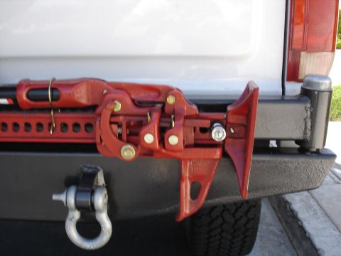 1996 Ford Bronco - Close up of highlift jack. It's mounted on two 1/2" wheel studs with wheel locks for security.