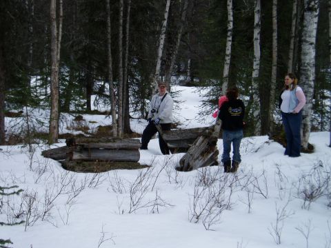 2000 Ford E350 - People gathered in a wooded area during winter, with snow covering the ground.