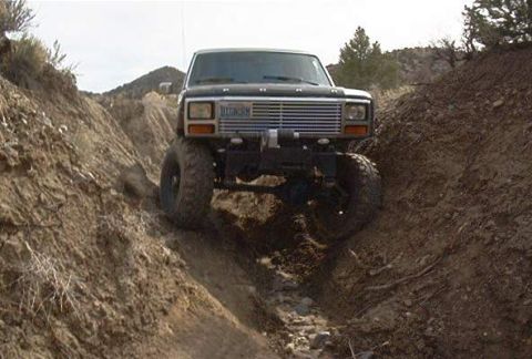 1986 Ford Bronco - This Ford Bronco is navigating a steep, rocky terrain, its off-road capabilities.