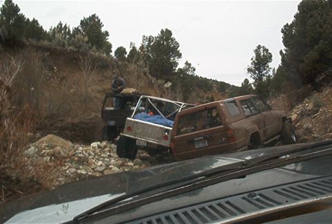 1986 Ford Bronco - A brown Toyota 4Runner navigates a rocky off-road trail with another vehicle behind it.