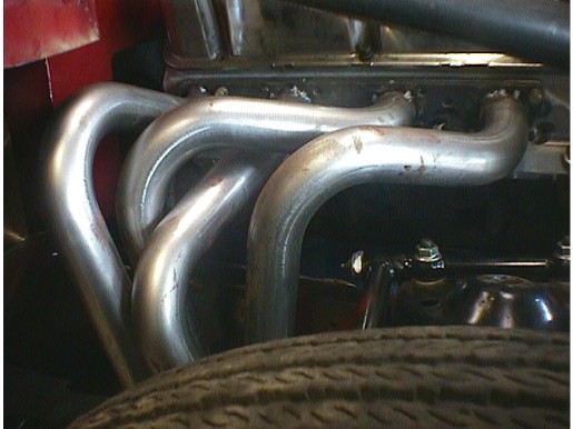 Polished tubular exhaust headers in an engine bay