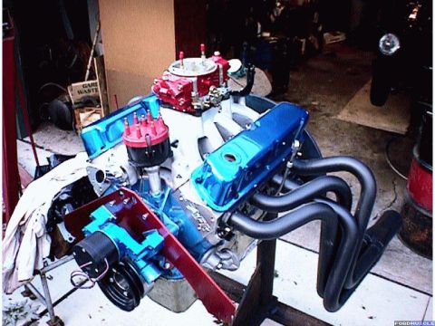 1960 Ford Falcon - Engine assembly with blue valve covers and red distributor cap, mounted on a stand.
