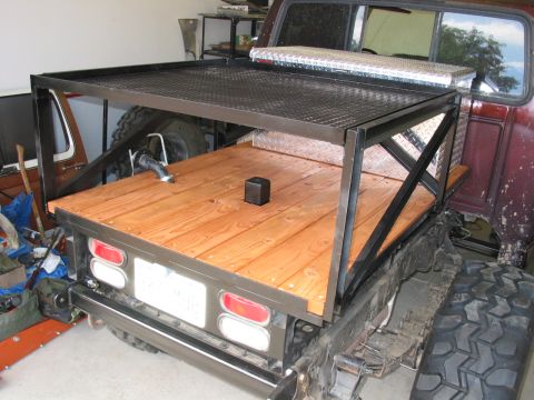 1981 Ford Bronco - A custom flatbed modification is attached to the rear of a pickup truck.