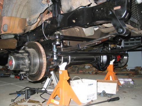 1981 Ford Bronco - Vehicle's rear suspension and axle assembly are supported by jack stands during maintenance or repair.