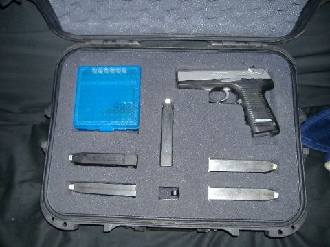 1979 Ford Bronco - A handgun, multiple magazines, and a blue cartridge holder are neatly arranged in a black protective case.